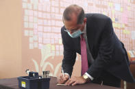 U.S. Health and Human Services Secretary Alex Azar writes a note at a memorial for former Taiwanese President Lee Teng-hui in Taipei, Taiwan, Wednesday, Aug. 12, 2020. Wednesday is the last day of Azar's schedule during the highest-level visit by an American Cabinet official since the break in formal diplomatic ties between Washington and Taipei in 1979. (Wang Teng-yi/Pool Photo via AP)