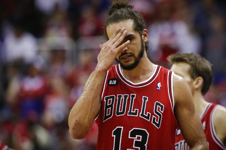 Chicago Bulls center Joakim Noah (13) holds his hand to his head during a break in the action against the Washington Wizards during the first half of Game 4 of an opening-round NBA basketball playoff series in Washington, Sunday, April 27, 2014. (AP Photo/Alex Brandon)