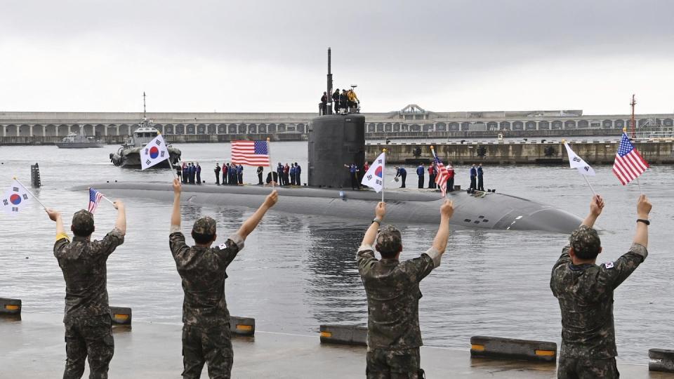 In this photo provided by South Korea Defense Ministry, South Korean navy sailors wave as the U.S. nuclear-powered submarine Annapolis arrives at a South Korean naval base on Jeju Island, South Korea, Monday, July 24, 2023. (South Korea Defense Ministry via AP)