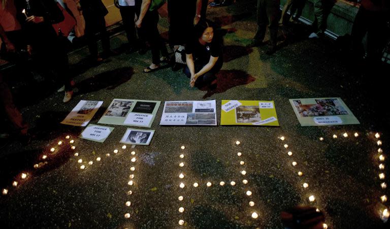 People hold a candle-light vigil in Kuala Lumpur on July 19, 2014, for the victims of Malaysia Airlines flight MH17 that crashed in east Ukraine