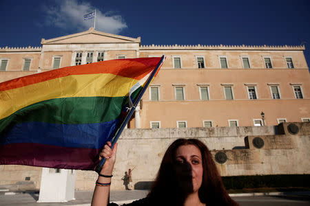 A protester waves a rainbow flag during a demonstration as the Greek Parliament debates bill allowing people to choose legal gender, in Athens, Greece, October 9, 2017. REUTERS/Alkis Konstantinidis
