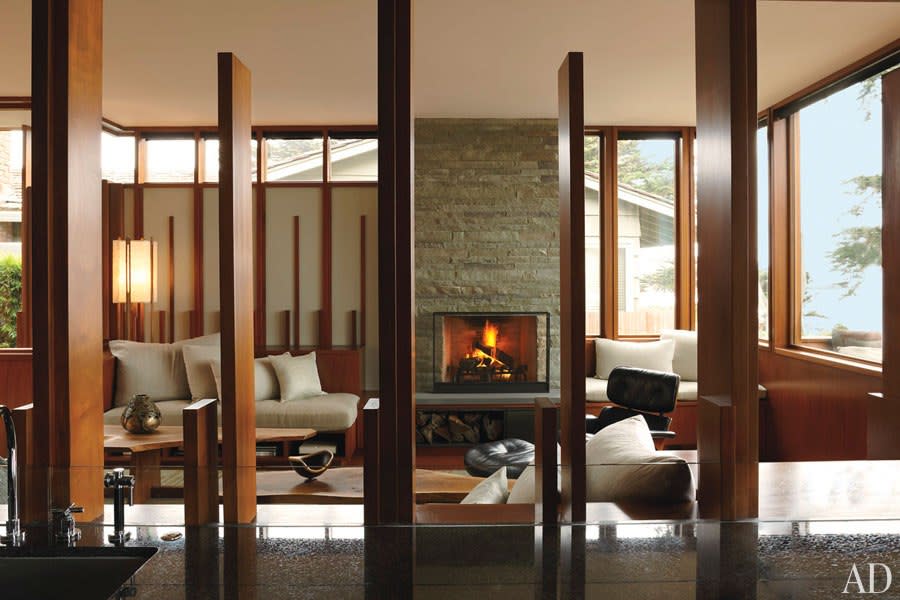 Widely spaced mahogany panels serve as screens to define the living room, where built-in seating and cabinetry are paired with Nakashima low tables. (Photo: David Matheson)