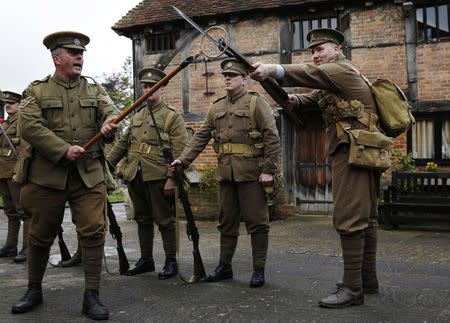 Factory landlord Lawrence Taylor (L), portraying a Colour Sergeant from the King's Royal Rifle Corps, part of the Rifles Living History Society, performs a drill with Connor Young (R) of the Queen's Own Royal West Kent Regiment Living History Group as they recreate the life of a First World War soldier at the Eden Valley Museum in Edenbridge in southeast England May 10, 2014. REUTERS/Luke MacGregor