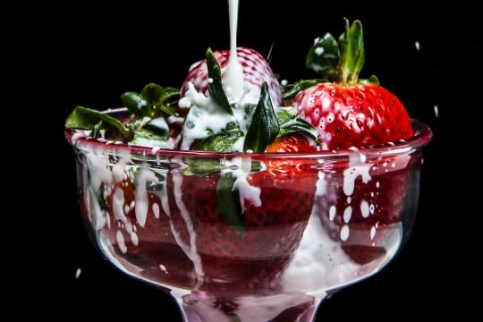 Strawberries in a glass, splashed with cream milk