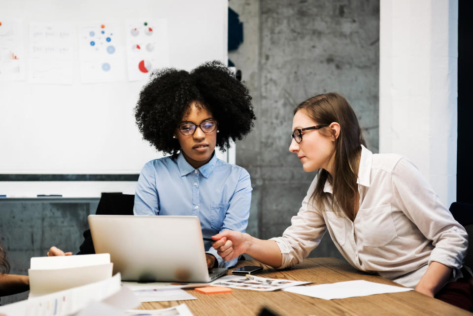 two women coworkers working with one another