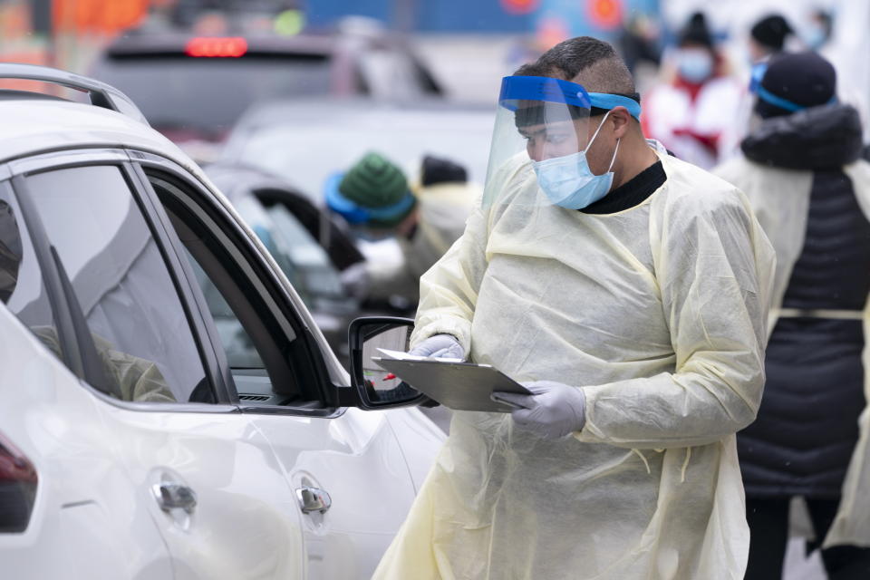 A health-care worker screens people in their vehicle at a COVID-19 test clinic in Montreal on Monday, March 23, 2020. (Paul Chiasson/The Canadian Press via AP)