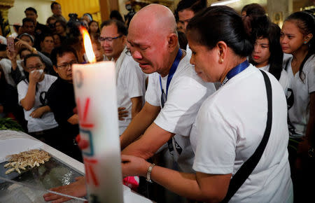 The parents of Kian delos Santos, a 17-year-old student who was shot during anti-drug operations stops grieve during a funeral mass inside a church Caloocan, Metro Manila, Philippines August 26, 2017. REUTERS/Dondi Tawatao