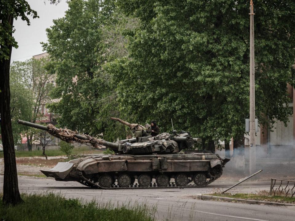 A Ukrainian main battle tank drives on a street during nearby mortar shelling in Sievierodonetsk (AFP via Getty Images)