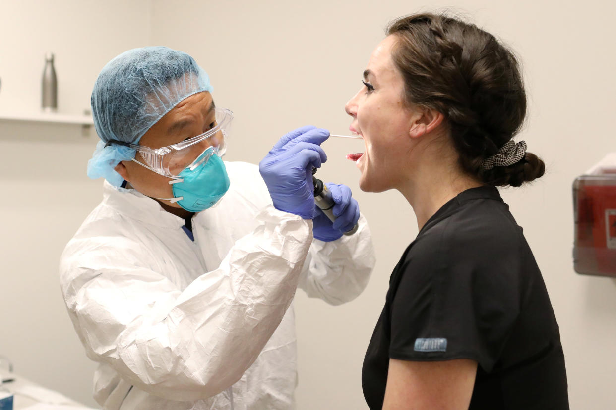 Physician John Jones, D.O. tests administrative assistant Morgan Bassin for the coronavirus disease (COVID-19) at One Medical in Scottsdale, Arizona, U.S. June 17, 2020. One Medical employees receive testing every two weeks.   REUTERS/Courtney Pedroza