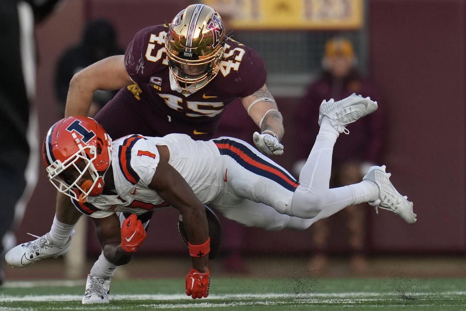 Illinois wide receiver Isaiah Williams (1) fumbles the football after catching a pass as Minnesota linebacker Cody Lindenberg (45) tackles him during the second half of an NCAA college football game Saturday, Nov. 4, 2023, in Minneapolis. (AP Photo/Abbie Parr)