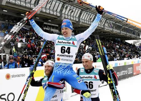 FIS Nordic Ski World Championships - Men's Cross-Country 15 km Classical - Lahti, Finland - 1/3/17 - Iivo Niskanen of Finland is lifted by Martin Jonsrud Sundby and Niklas Dyrhaug of Norway. Lehtikuva/Martti Kainulainen via REUTERS