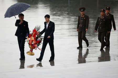 People carry flowers as they arrive to pay respects at the statues of North Korea founder Kim Il Sung and late leader Kim Jong Il in Pyongyang, North Korea April 14, 2017. REUTERS/Damir Sagolj
