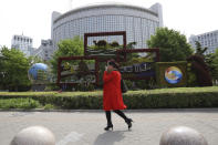 A woman walks past a decoration promoting the upcoming Road and Belt Forum outside the Chinese Foreign Ministry in Beijing on Friday, April 19, 2019. China is downplaying the political implications of its global development campaign known as the Belt and Road initiative, saying that it aims to boost multilateralism amid protectionist trends in the U.S. and elsewhere. (AP Photo/Ng Han Guan)