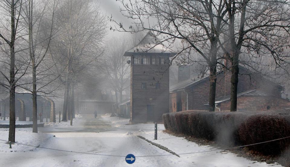 This photo taken taken through a metal fence on Friday, Jan. 27, 2017 in Oswiecim, Poland, shows a guard's tower of the former Nazi German death camp of Auschwitz that the Nazis operated in occupied Poland during World War II. Poland's historians have put online what they say is the most complete list of Nazi SS commanders and guards at Auschwitz, in hopes some of them can still be brought to justice. (AP Photo/Czarek Sokolowski)