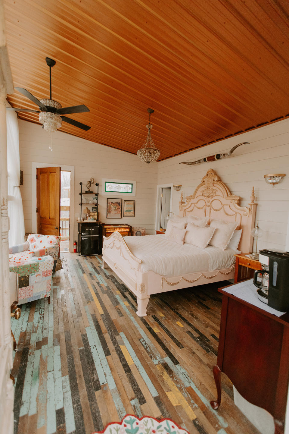 The bedroom's colorful wood floors are reclaimed from a mid-20th century manufacturing plant. Photo credit: Zach and Sarah Photography.