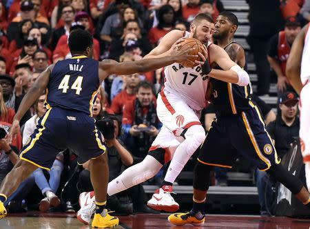 Toronto Raptors center Jonas Valanciunas (17) drives past Indiana Pacers forward Solomon Hill (44) and is fouled by forward Paul George (13) in game seven of the first round of the 2016 NBA Playoffs at Air Canada Centre. Mandatory Credit: Dan Hamilton-USA TODAY Sports