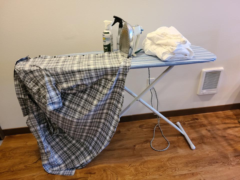 This April 1, 2020 photo released by Bill Hughes shows one of Hughes' shirts on an ironing board at his home in University Place, Wash. Hughes, a business consultant, has resorted to ironing his own clothes now that his dry cleaners is closed. (Bill Hughes via AP)