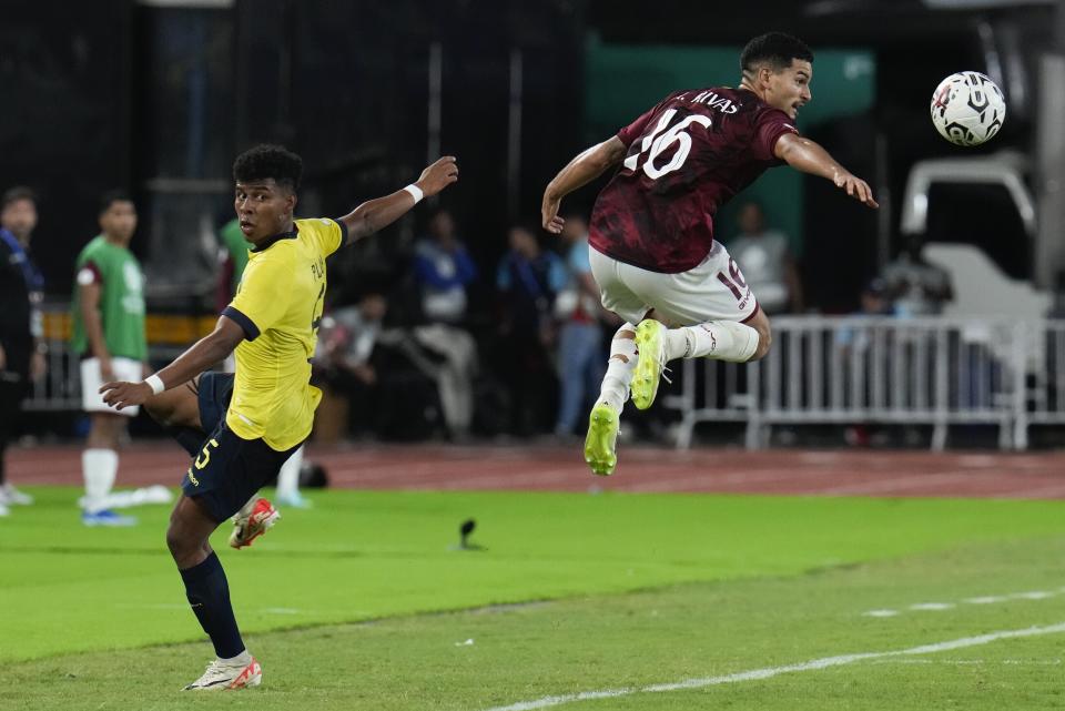 Renné Rivas, de la selección de Venezuela, controla el balón detrás de Erick Plúas, de Ecuador, durante un encuentro del Preolímpico Sudamericano, el martes 23 de enero de 2024 (AP Foto/Ariana Cubillos)