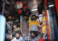 Daily wage laborers, returning from Mumbai travel to their villages amid Coronavirus concerns in a crowded train coach in Prayagraj , India, Sunday, March 22, 2020. India is observing a 14-hour “people's curfew” called by Prime Minister Narendra Modi in order to stem the rising coronavirus caseload in the country of 1.3 billion. For most people, the new coronavirus causes only mild or moderate symptoms. For some it can cause more severe illness. (AP Photo/Rajesh Kumar Singh)