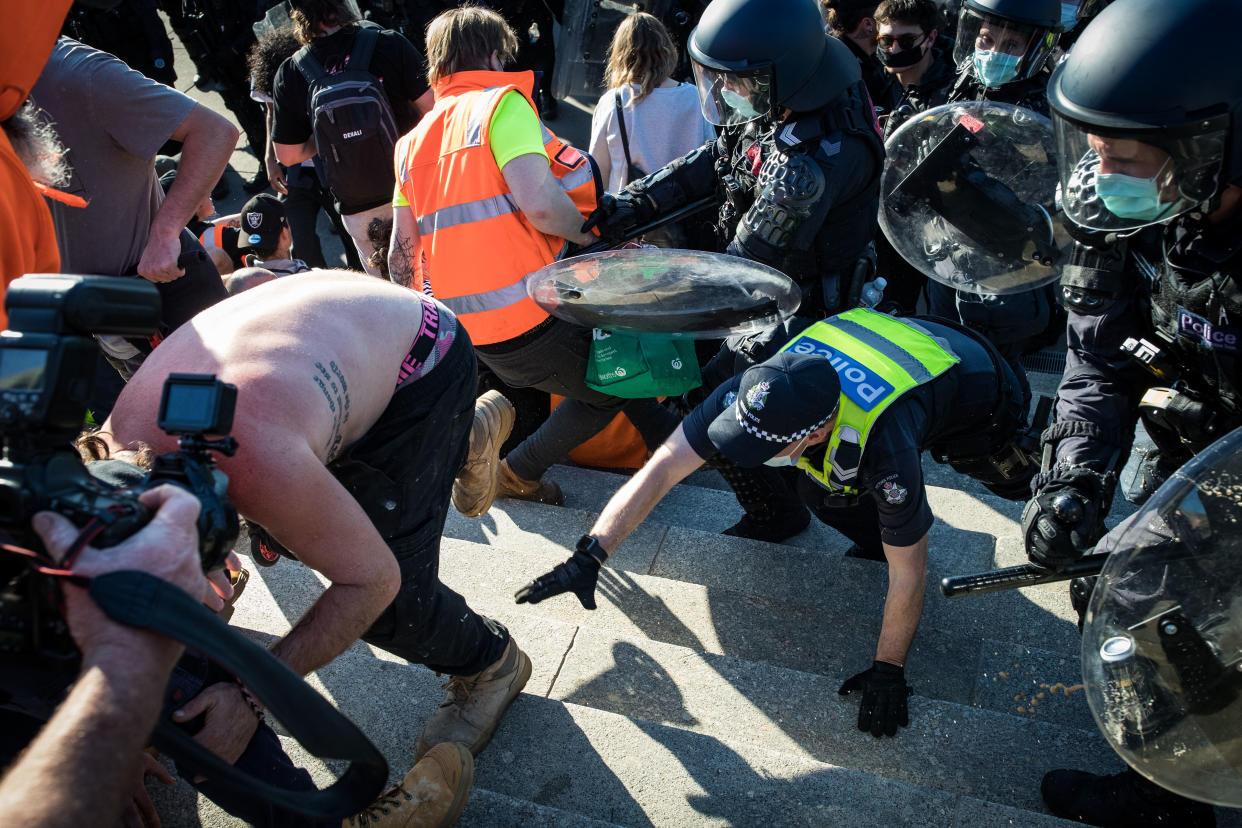 MELBOURNE, AUSTRALIA - SEPTEMBER 22: Members of Victoria Police and protesters clash at the Shrine of Remembrance  on September 22, 2021 in Melbourne, Australia. Protests started on Monday over new COVID-19 vaccine requirements for construction workers but  turned into larger and at times violent demonstrations against lockdown restrictions in general. Melbourne is currently subject to COVID-19 lockdown restrictions, with people only permitted to leave home for essential reasons. (Photo by Darrian Traynor/Getty Images)