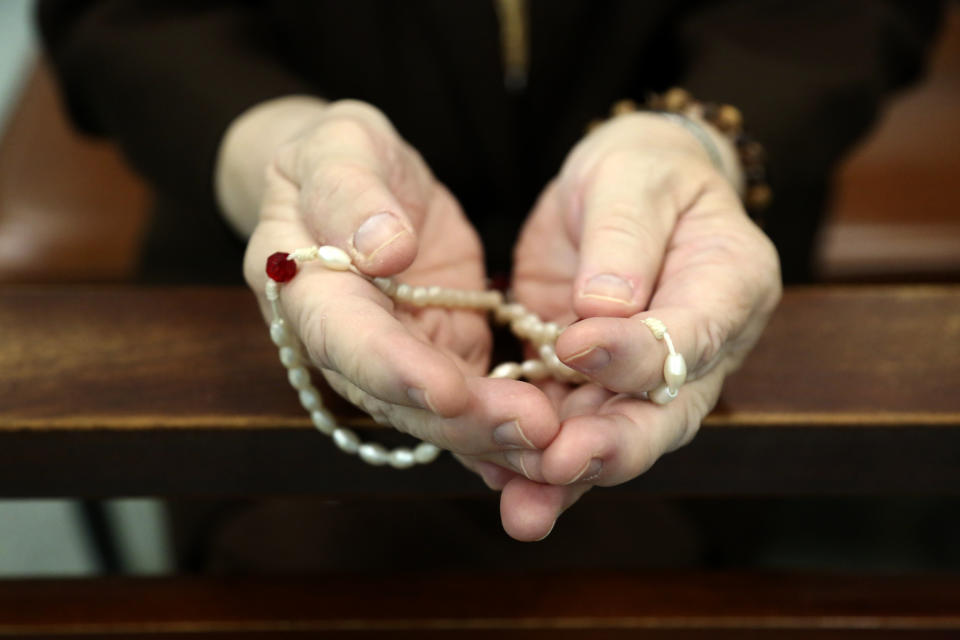 Sister Mary Carol Kardell, of the Felician Sisters of North America, prays with rosary beads during morning Mass at St. Anne Home in Greensburg, Pa., on Thursday, March 25, 2021. Communities of Catholic nuns are absorbing devastating losses from outbreaks of the coronavirus. The Felician Sisters lost 21 of their own, in four U.S. convents, a remarkable blow for a community of about 450 women. (AP Photo/Jessie Wardarski)