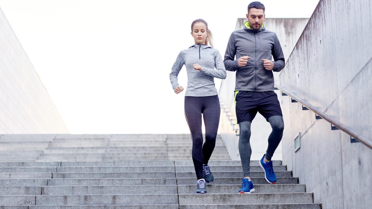  Man and woman side by side walking down steps during workout. 