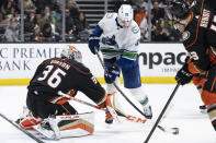 Anaheim Ducks goaltender John Gibson (36) pokes the puck away from Vancouver Canucks center Nils Aman (88) during the second period of an NHL hockey game in Anaheim, Calif., Sunday, March 19, 2023. (AP Photo/Kyusung Gong)