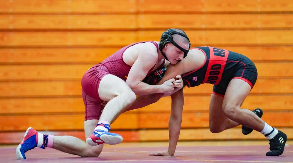 Bloomington North’s Cael Hickok (left) works against Edgewood’s Cayleb Stephens in the 157-pound match during their dual meet at North on Tuesday, Jan. 9, 2024.