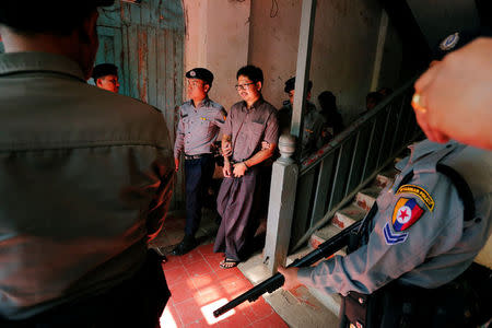 Detained Reuters journalist Wa Lone is escorted by police after a court hearing in Yangon, Myanmar March 7, 2018. REUTERS/Stringer NO RESALES NO ARCHIVES