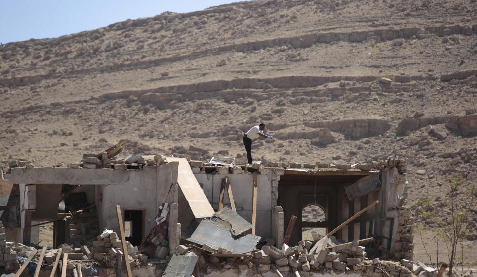 A forensic expert takes a photograph of a house destroyed by a Saudi-led airstrikes in the outskirts of Sanaa, Yemen, Thursday, Feb. 16, 2017. At least one Saudi-led airstrike near Yemen's rebel-held capital killed at least five people on Wednesday, the country's Houthi rebels and medical officials said. (AP Photo/Hani Mohammed)