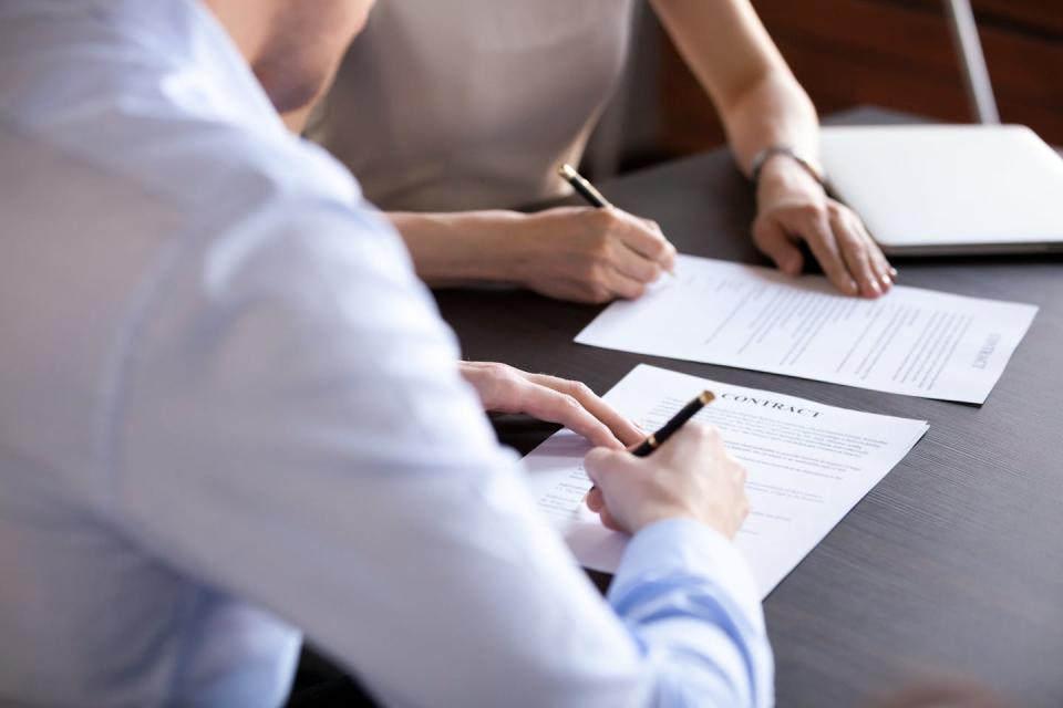 A man and a woman signing documents