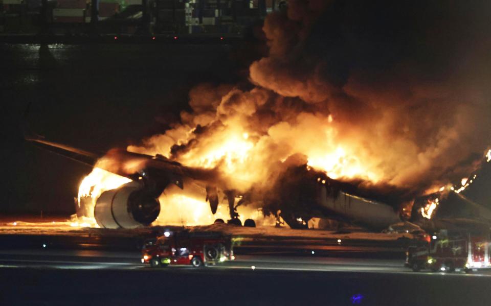 A Japan Airlines plane is on fire on the runway of Haneda airport on Tuesday (AP)