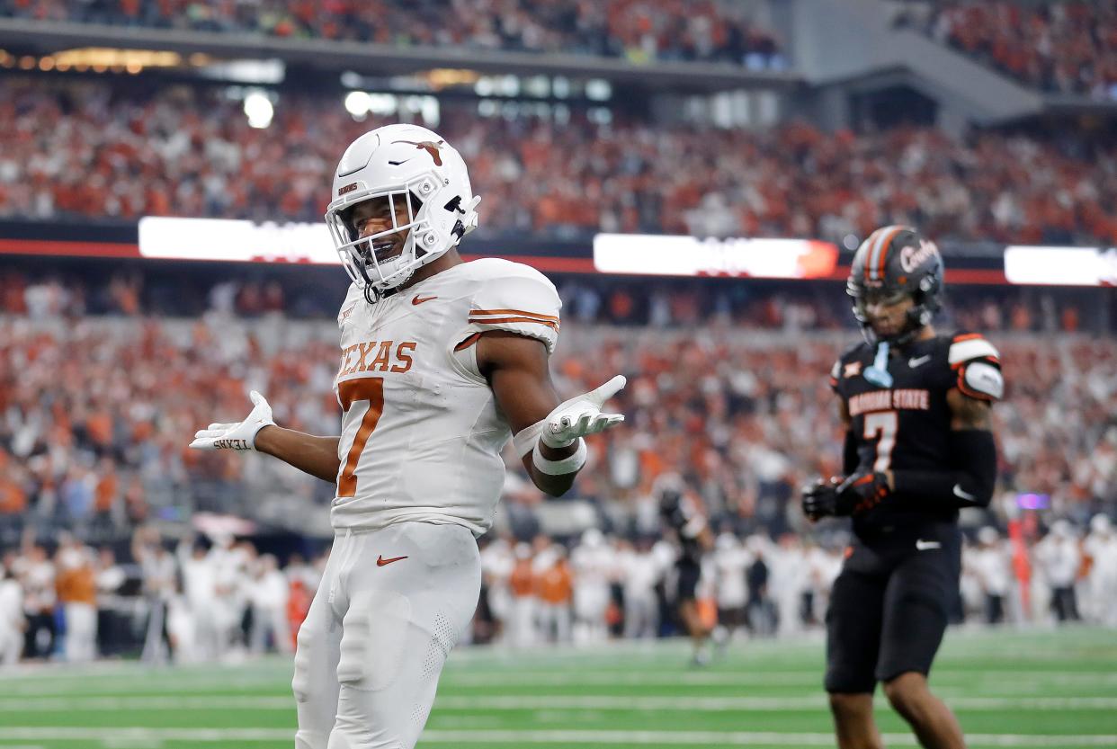 Texas' Keilan Robinson (7) celebrates a touchdown in front of Oklahoma State's Cameron Epps (7) in the second half of the Big 12 Football Championship game between the Oklahoma State University Cowboys and the Texas Longhorns at the AT&T Stadium in Arlington, Texas, Saturday, Dec. 2, 2023.