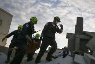 Rescue specialists for USA-1 carry a victim rescued from the scene of a mock disaster area during a training exercise at the Guardian Center in Perry, Georgia, March 25, 2014. (REUTERS/Shannon Stapleton)