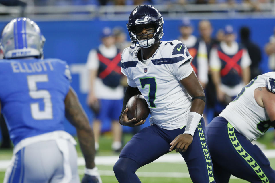 Seattle Seahawks quarterback Geno Smith avoids Detroit Lions safety DeShon Elliott (5) and runs into the end zone for a 8-yard touchdown run during the first half of an NFL football game, Sunday, Oct. 2, 2022, in Detroit. (AP Photo/Duane Burleson)
