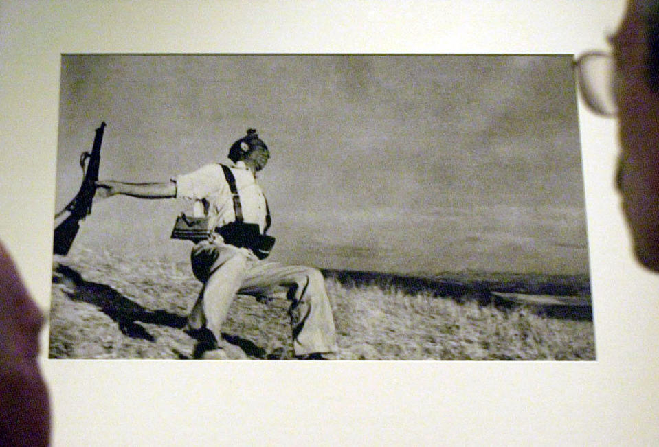 Bob Peters (L), 86, and son Rodney stare at Robert Capa's photograph, 'Death of a Militiaman' inside The Imperial War Museum's Spanish Civil War exhibition in London. Bob, served for the British Battallion and was shot in the spine on 7, July, 1937.  * two days after being sent to the front in the fighting, but still returned to action some weeks later to serve as a motorcycle dispatch rider.   (Photo by Johnny Green - PA Images/PA Images via Getty Images)