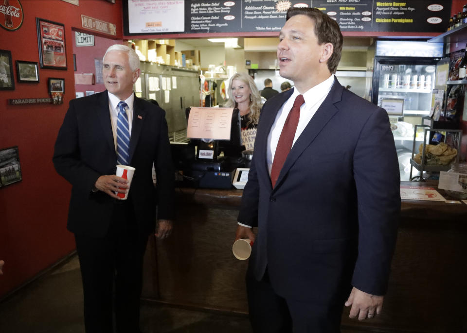 Florida Gov. Ron DeSantis, right, and Vice President Mike Pence eat lunch at Beth's Burger Bar on May 20, 2020, in Orlando, Fla. (Chris O'Meara/AP)