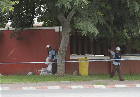 Cambodian Mine Action Center (CMAC) personnel prepare to detonate a bomb that security officials discovered outside of Cambodia's National Assembly in central Phnom Penh, September 13, 2013. REUTERS/Samrang Pring