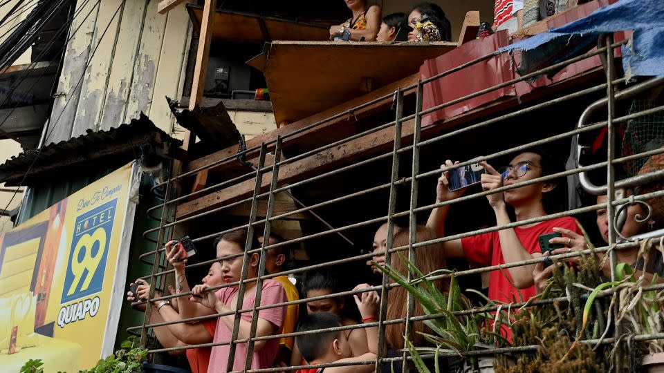 People watch the procession from their homes as the Black Nazarene statue passes by in Manila. - Jam Sta Rosa/AFP/Getty Images