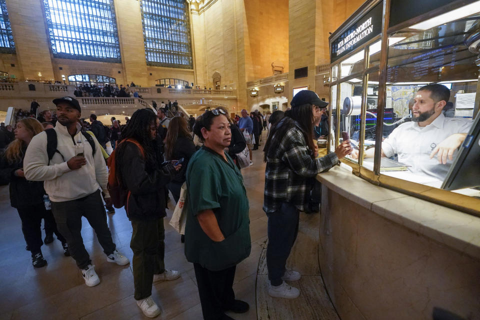 An MTA employee helps commuters at Grand Central Terminal information booth following a disruption in schedules dues to heavy rains, Friday, Sept. 29, 2023, in New York. (AP Photo/Mary Altaffer)