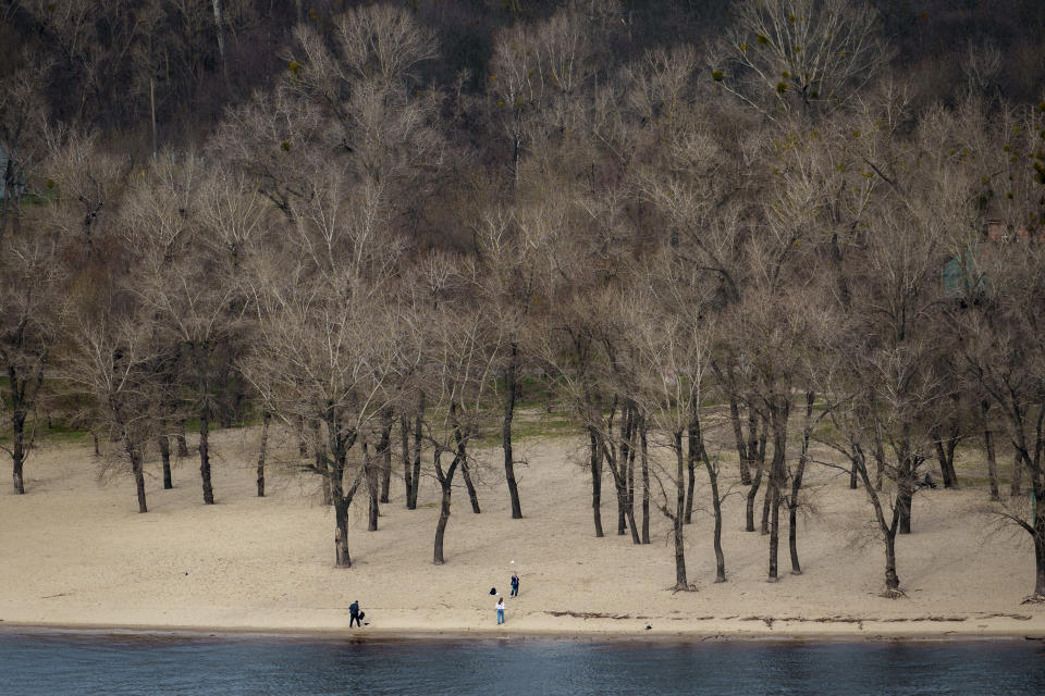 People play on the bank of the Dniepr River, in Kyiv, Ukraine, Thursday, March 28, 2024. (AP Photo/Vadim Ghirda)