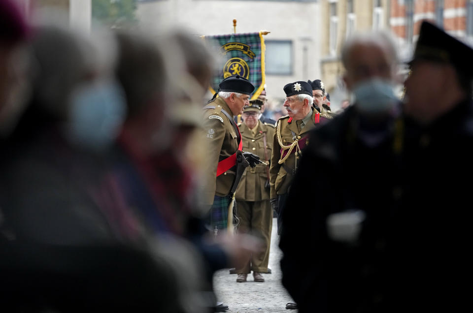 Two participants from the St. Andrew Scottish Guard, center, wait to march during an Armistice Day ceremony at the Menin Gate Memorial to the Missing in Ypres, Belgium, Thursday, Nov. 11, 2021. (AP Photo/Virginia Mayo)