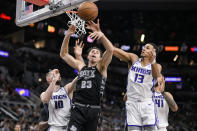 San Antonio Spurs' Zach Collins (23) tangles with Sacramento Kings' Keegan Murray (13) and Domantas Sabonis (10) during the second half of an NBA basketball game, Sunday, Jan. 15, 2023, in San Antonio. (AP Photo/Darren Abate)