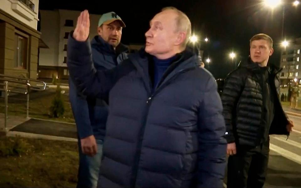 Putin waves to residents after visiting their new flat in Mariupol - POOL Russian TV