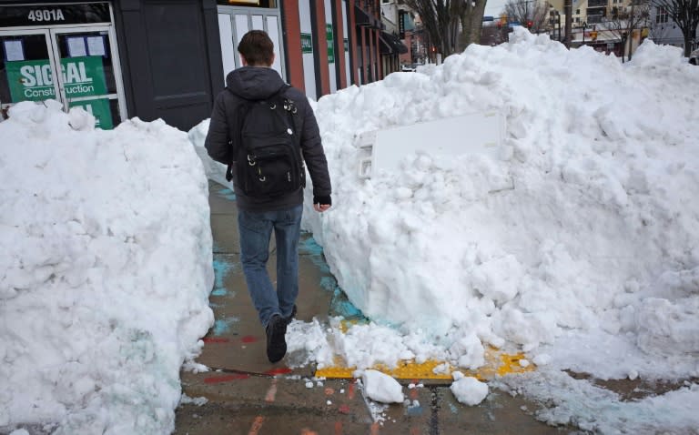 A man walks through a large mound of snow in Bethesda, Maryland on January 26, 2016