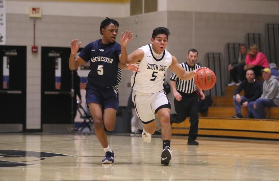 South Side's Alex Arrigo (right) drives down the court while being guarded by Rochester's Xavier Rigby (left) during the first half Friday night at South Side High School.