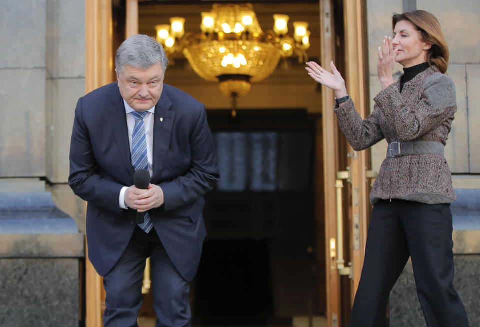 Ukrainian President Petro Poroshenko bows during a meeting with supporters who have come to thank him for his work as a president, as his wife, Maryna, applauds, in Kiev, Ukraine, Monday, April 22, 2019. (AP Photo/Vadim Ghirda)