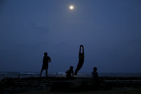 Children play under the full moon on Achutupu Island in the Guna Yala region, Panama May 2, 2015. REUTERS/Carlos Jasso