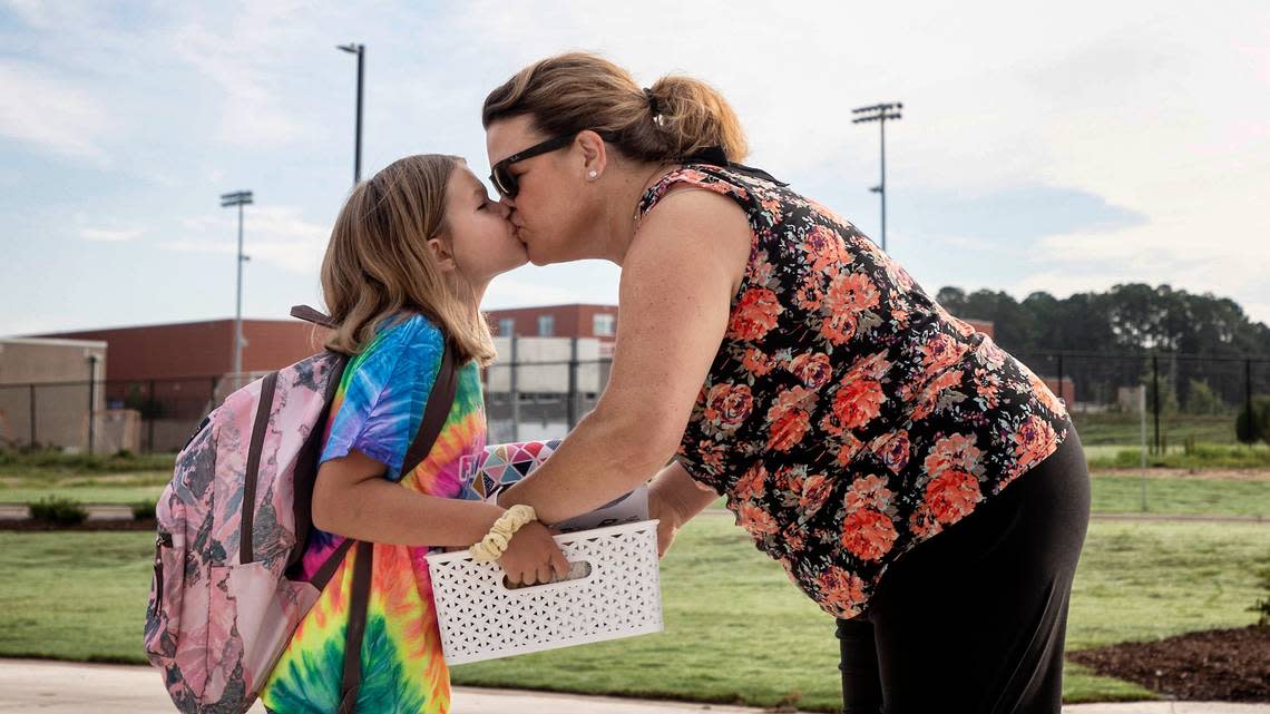 Abby Howe, 8, kisses Angie Howe prior to her first day of third grade on Monday, Aug. 29, 2022, at Apex Friendship Elementary School in Apex, N.C.