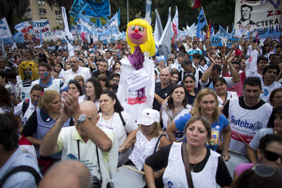 A puppet representing a teacher with a sign attached that reads in Spanish; "In favor of public education," stands in a crowd of hundreds of teachers during a demonstration outside the Ministry of Education in Buenos Aires, Argentina, Wednesday, March 26, 2014. Striking teachers in the Buenos Aires province are demanding a wage increase higher than what is currently being offered by the provincial administration. The strike is in its 15th day, affecting more than 3 million students. (AP Photo/Victor R. Caivano)